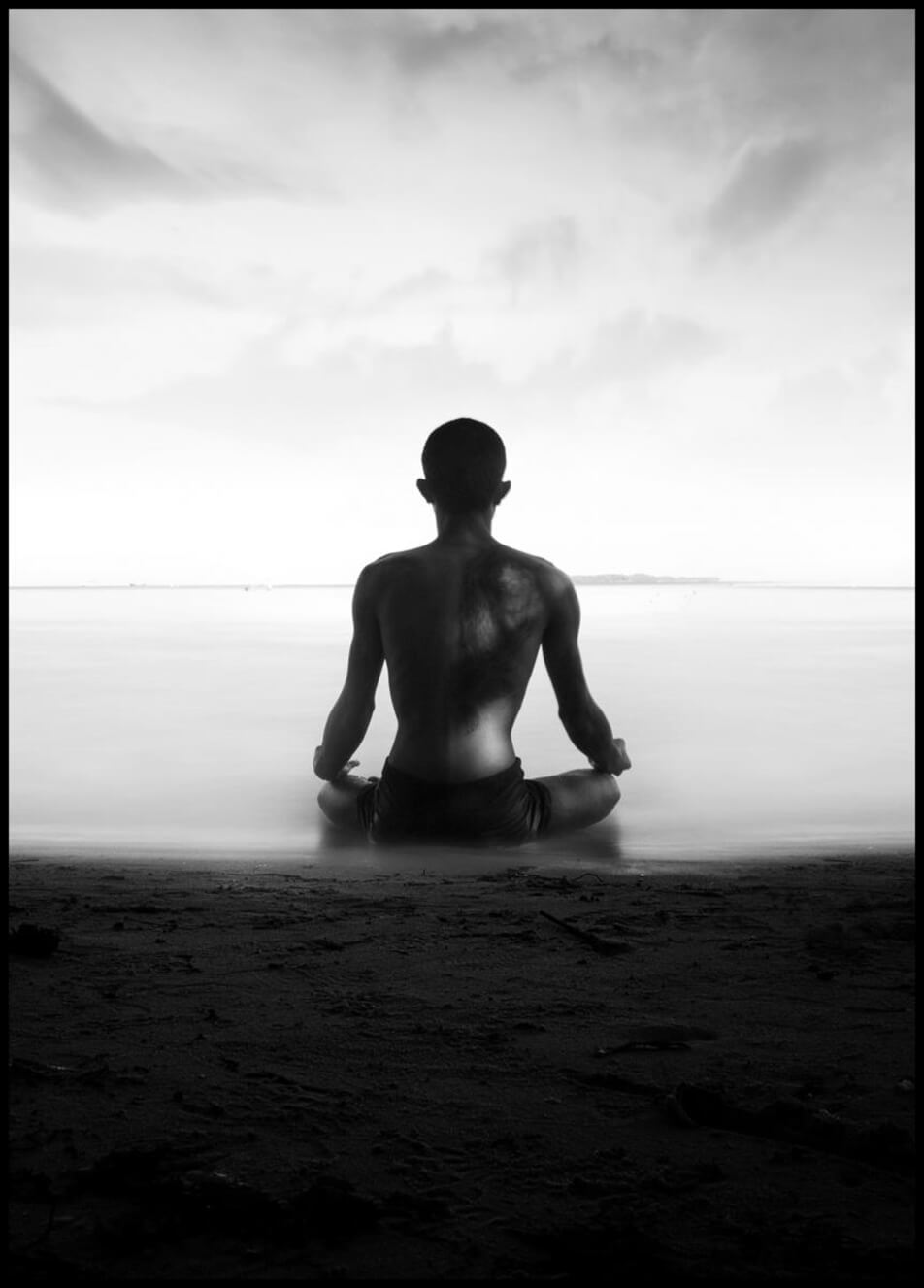 Poster med foto föreställande en man som mediterar vid strandkant